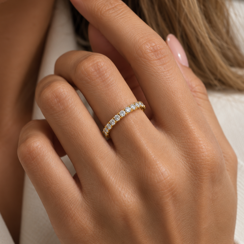A 14K yellow gold eternity band worn on hands