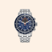 Citizen watch with blue face and silver metal strap on a beige background