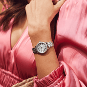 Silver  citizen eco-drive watch on a wrist with a pink dress