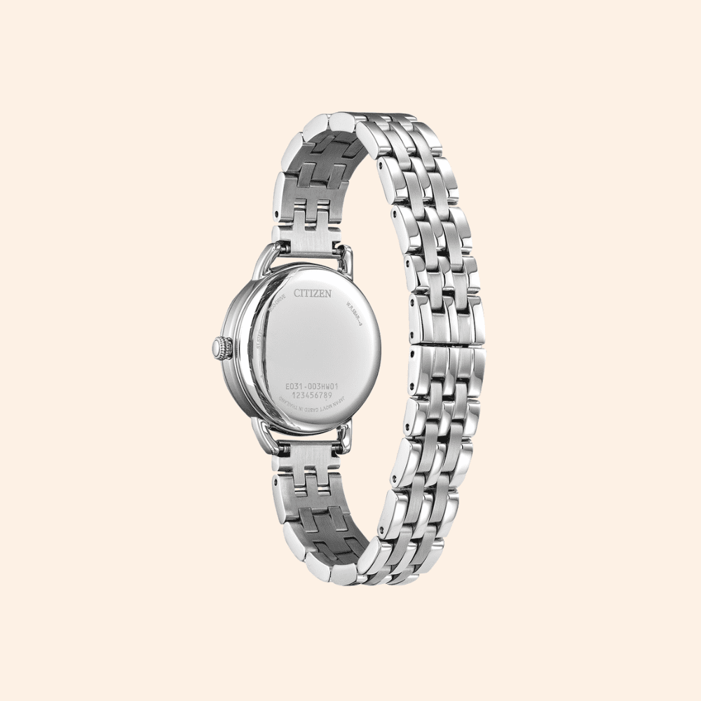 Silver citizen watch with a detailed band on a light beige background