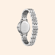 Silver citizen watch with a detailed band on a light beige background