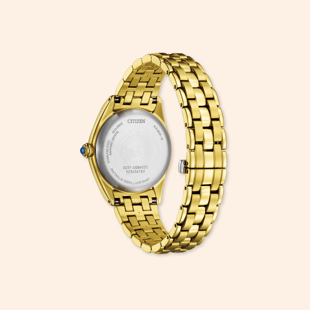 Gold watch with a visible citizen brand logo on a beige background