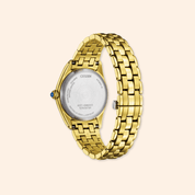 Gold watch with a visible citizen brand logo on a beige background