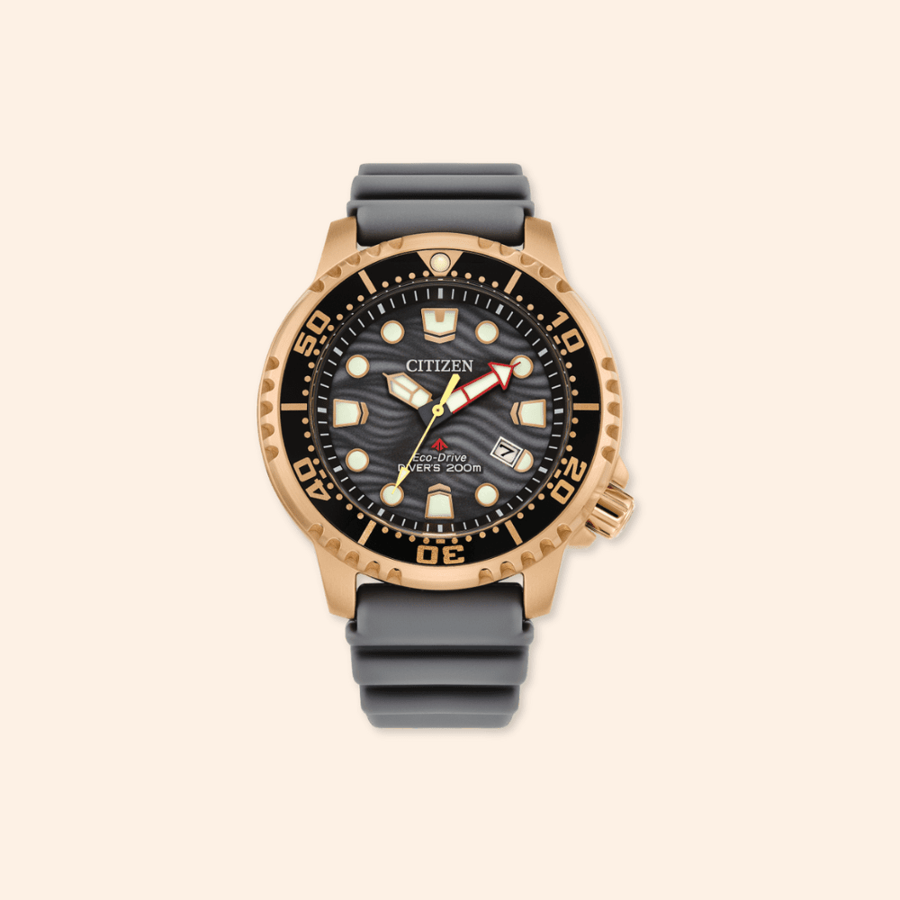 Citizen divers watch with black strap and rose gold case on beige background