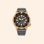 Citizen divers watch with black strap and rose gold case on beige background