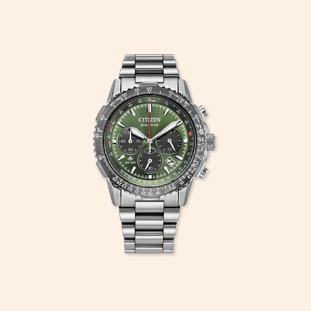 Silver Citizen watch with a green face on a beige background