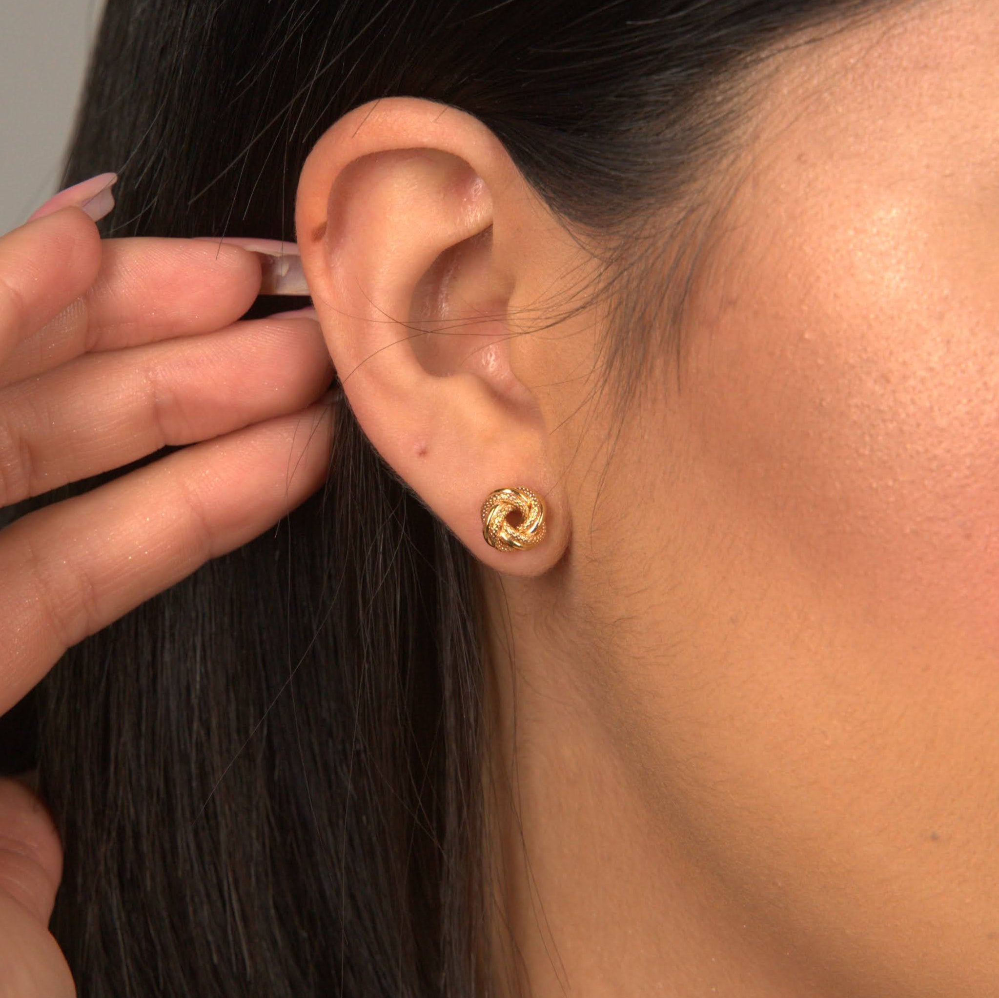 woman wearing love knot studs