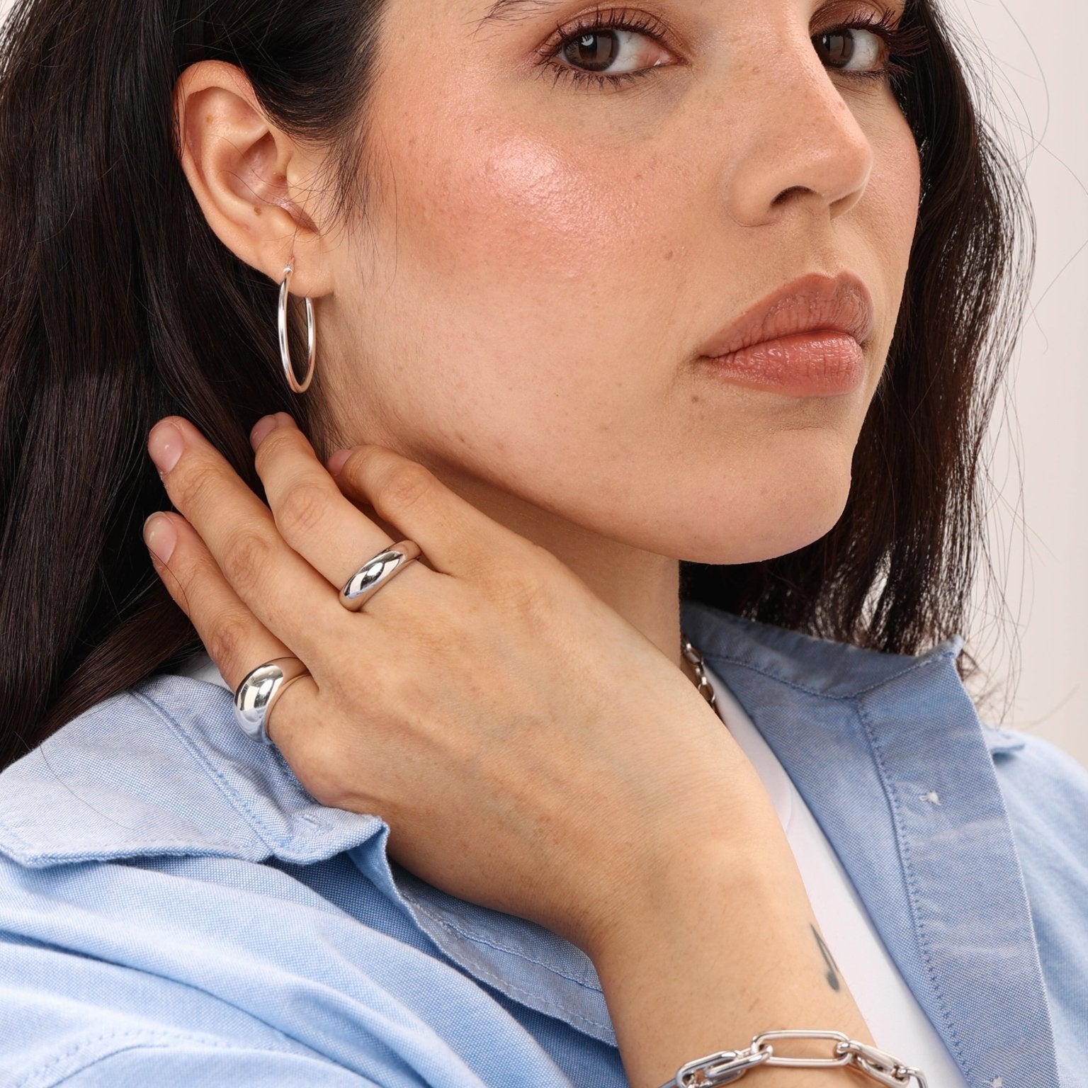 woman styling silver medium dome ring with other jewellery
