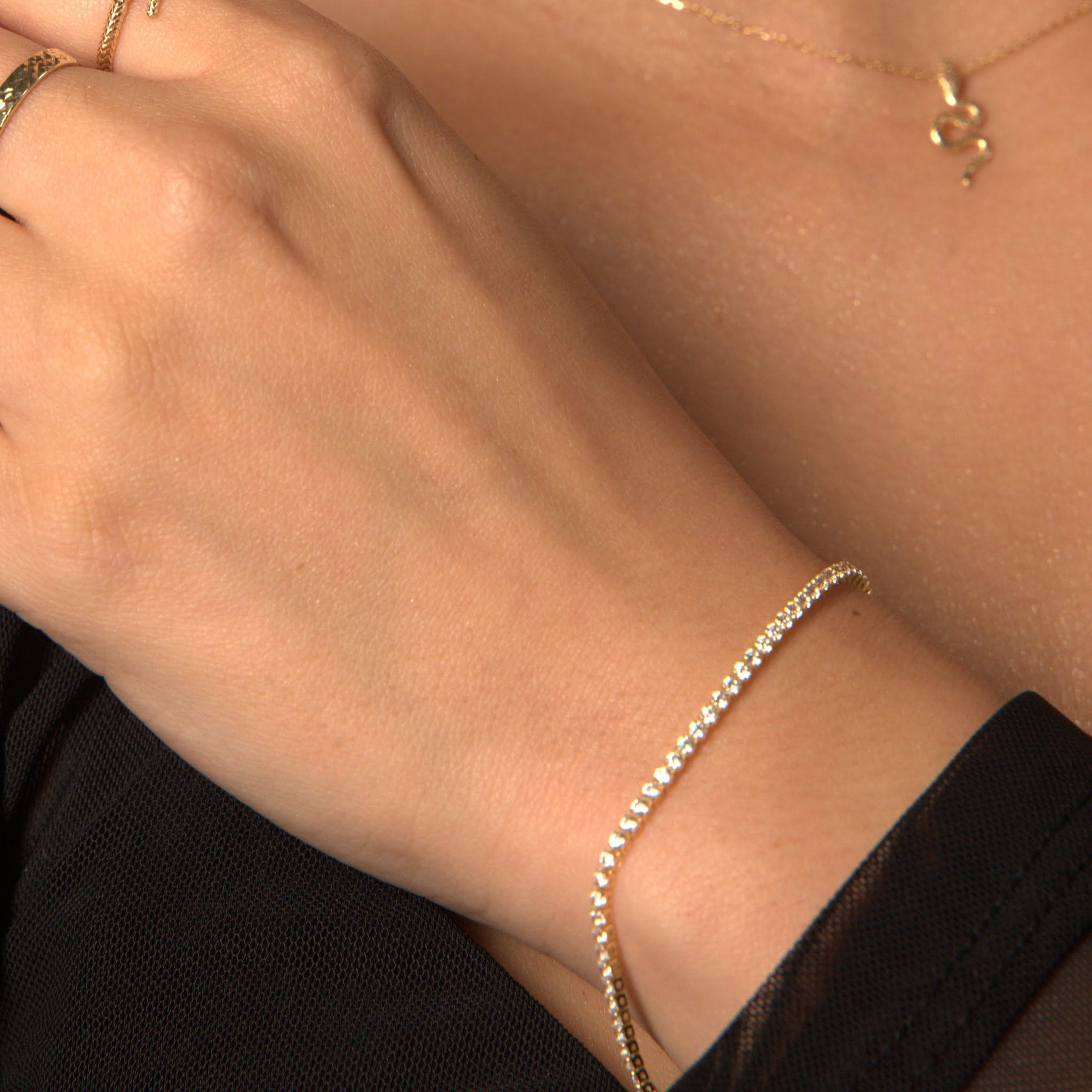 woman wearing 10K gold tennis bracelet on wrist, elegant fine jewellery style